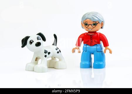 KHARKIV, UCRAINA - 29 marzo 2020: Giocattolo uomo cammina cane giocattolo, giocattoli di plastica, tema di educazione prescolare, isolato su bianco Foto Stock