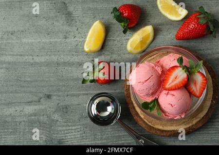 Ciotola con palle di gelato e ingredienti su texture grigia sfondo Foto Stock