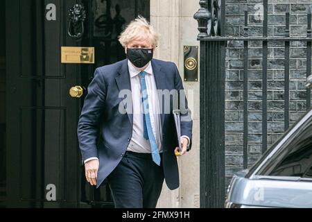 WESTMINSTER LONDRA 12 maggio 2021. Il primo Ministro Boris Johnson, che indossa una maschera protettiva, lascia 10 Downing Street per partecipare alle interrogazioni settimanali dei primi Ministri del PMQS un giorno dopo l'apertura dello Stato del Parlamento. PM Boris Johnson ha annunciato un'indagine pubblica di Covid sulla gestione della pandemia del coronavirus che inizierà nel 2022 Credit amer Ghazzal/Alamy Live News Foto Stock