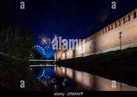 un divertente festival della città termina con un festoso spettacolo di fuochi d'artificio. le colorate esplosioni di fuochi d'artificio nel cielo serale si riflettono nell'acqua Foto Stock