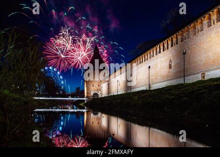 un divertente festival della città termina con un festoso spettacolo di fuochi d'artificio. le colorate esplosioni di fuochi d'artificio nel cielo serale si riflettono nell'acqua Foto Stock