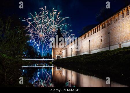 un divertente festival della città termina con un festoso spettacolo di fuochi d'artificio. le colorate esplosioni di fuochi d'artificio nel cielo serale si riflettono nell'acqua Foto Stock