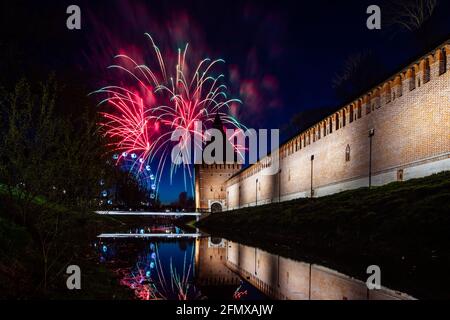 un divertente festival della città termina con un festoso spettacolo di fuochi d'artificio. le colorate esplosioni di fuochi d'artificio nel cielo serale si riflettono nell'acqua Foto Stock