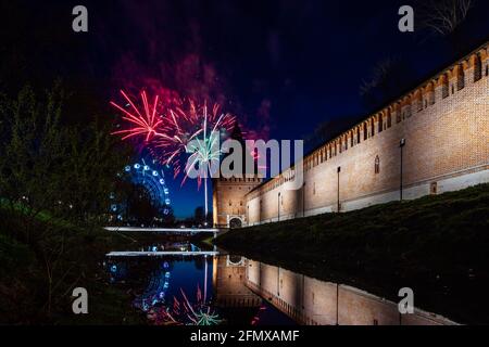 un divertente festival della città termina con un festoso spettacolo di fuochi d'artificio. le colorate esplosioni di fuochi d'artificio nel cielo serale si riflettono nell'acqua Foto Stock