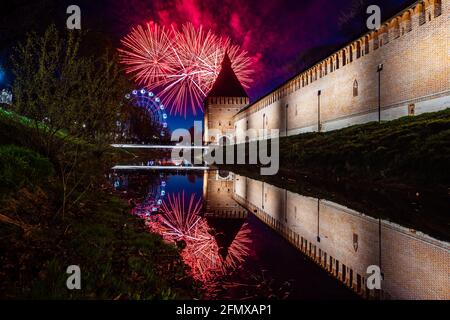 un divertente festival della città termina con un festoso spettacolo di fuochi d'artificio. le colorate esplosioni di fuochi d'artificio nel cielo serale si riflettono nell'acqua Foto Stock