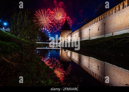 un divertente festival della città termina con un festoso spettacolo di fuochi d'artificio. le colorate esplosioni di fuochi d'artificio nel cielo serale si riflettono nell'acqua Foto Stock