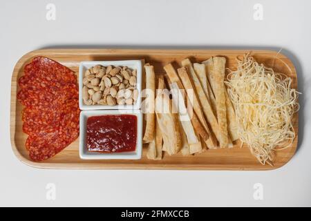 antipasti di birra con arachidi, salumi, toast e formaggi su tavola di legno isolata Foto Stock