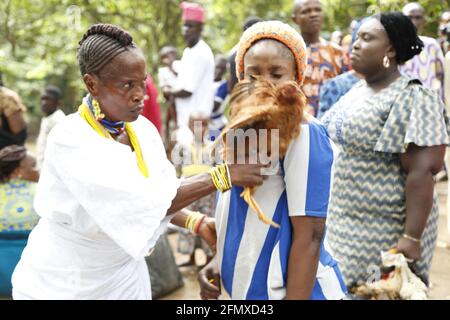 Osun Osogbo: Sacerdotessa di Osun che prega per una donna sterile con una gallina sacrificale durante il Festival Osun Osogbo. Foto Stock