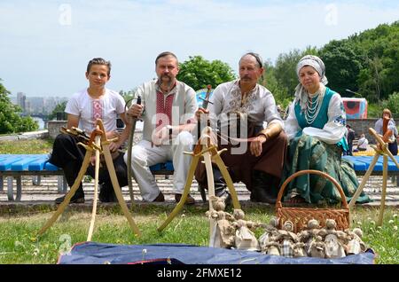 Venditori ambulanti in costumi tradizionali di ricamo ucraini seduti su una panchina che vende souvenir nativi nel parco comunale della città. 8 maggio 2019. Kiev, Foto Stock