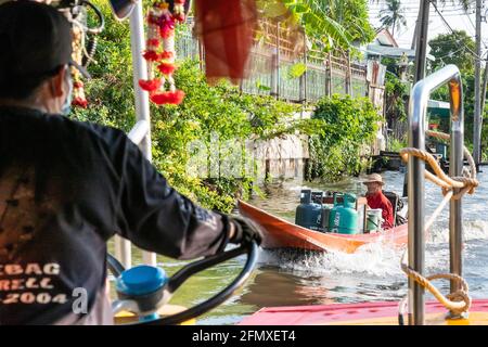 L'autista della barca guida la crociera sul khlong vicino al fiume Chao Phraya, Bangkok, Thailandia Foto Stock