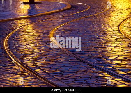 Strade di Praga con ciottoli e tram. Foto Stock