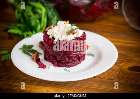 insalata dietetica di barbabietole bollite con noci e formaggio di cottage su un tavolo di legno Foto Stock