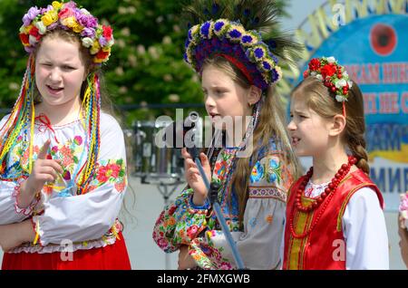 Tre bambine in costumi tradizionali di ricamo ucraini che cantano durante il concerto dedicato alla Giornata della memoria. 8 maggio 2019. Kiev, Ucraina Foto Stock