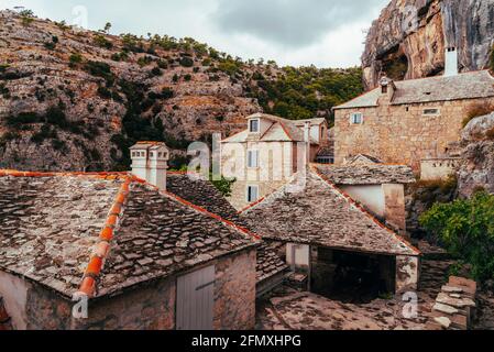 Case di pietra di Pustinja Blaca eremo, monastero sull'isola di Brac, Croazia Foto Stock