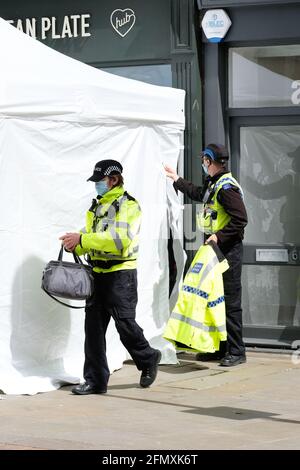 Gloucester, Gloucestershire, Regno Unito - Mercoledì 12 maggio 2021 - la polizia continua la loro ricerca presso il clean plate cafe nel centro della città. Gli ufficiali stanno cercando Mary Bastholm che è andato scomparendo in 1968 ha appena 15 anni e che può essere stata una vittima del serial killer Fred West. La foto mostra gli ufficiali di polizia sulla scena a metà pomeriggio. Photo Steven May / Alamy Live News Foto Stock