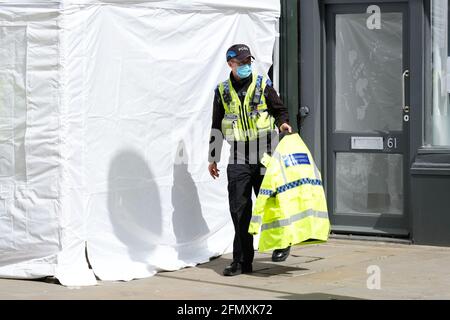 Gloucester, Gloucestershire, Regno Unito - Mercoledì 12 maggio 2021 - la polizia continua la loro ricerca presso il clean plate cafe nel centro della città. Gli ufficiali stanno cercando Mary Bastholm che è andato scomparendo in 1968 ha appena 15 anni e che può essere stata una vittima del serial killer Fred West. La foto mostra un ufficiale di polizia sulla scena a metà pomeriggio. Photo Steven May / Alamy Live News Foto Stock