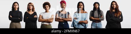 Donne multietniche in piedi insieme con le armi incrociate. Giovani donne forti con etnie diverse. Foto Stock