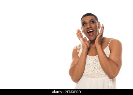 stupito uomo travestito afroamericano in spogliatore che tiene le mani vicino faccia isolata su bianco Foto Stock