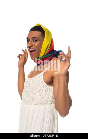 entusiasta uomo travestito afro-americano in abiti e colori arcobaleno il fazzoletto della testa è isolato su bianco Foto Stock