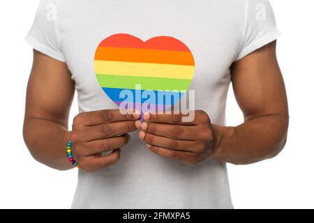 vista parziale dell'uomo afroamericano che mostra carta colori lgbt cuore isolato su bianco Foto Stock