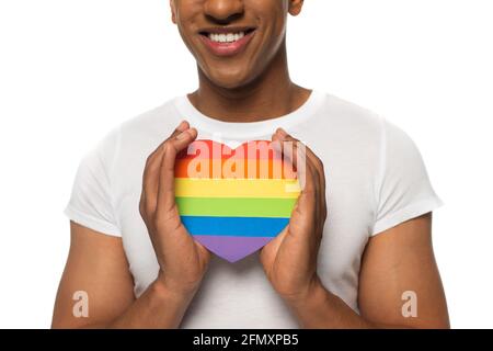 vista parziale dell'uomo afroamericano che detiene carta colori lgbt cuore isolato su bianco Foto Stock