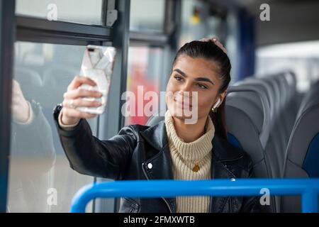 Una donna che prende una setta di se stessa su un autobus Foto Stock