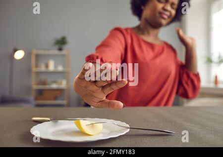 Infastidita giovane donna affamata odia stare e spinge piatto con pezzo di mela via Foto Stock