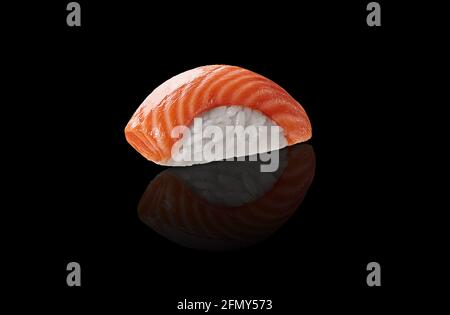 Un sushi nigiri con salmone su sfondo nero con riflessi Foto Stock
