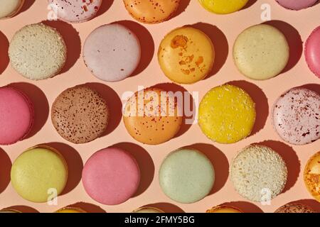 Vista dall'alto di macaron colorati su sfondo rosato Foto Stock
