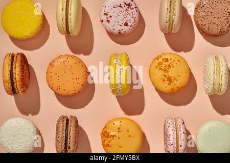 Vista dall'alto dei colorati macaron sandwich-cookie su sfondo rosa Foto Stock