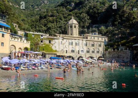 Abbazia e spiaggia di San Fruttuoso. Molte persone godono di una nuotata nelle acque color turchese. Foto Stock