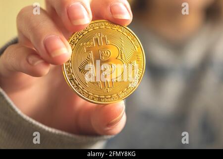 Bitcoin crypto moneta in mano primo piano di affari sfondo, foto d'oro criptovaluta Foto Stock