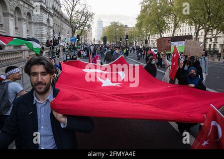 Londra, Regno Unito. 11 Maggio 2021. I manifestanti marciano in Parliament Street con un'enorme bandiera turca, mentre migliaia di persone partecipano a un rally di emergenza in solidarietà con il popolo palestinese organizzato dalla Campagna di solidarietà palestinese, gli amici di al Aqsa, la coalizione di arresto della guerra e il Forum palestinese in Gran Bretagna. Il raduno si è svolto in protesta contro le incursioni aeree israeliane a Gaza, lo spiegamento delle forze israeliane contro i fedeli alla moschea di al-Aqsa durante il Ramadan e i tentativi di spostare forzatamente le famiglie palestinesi dal quartiere dello Sheikh Jarrah di Gerusalemme Est. Credito: Mark Kerrison/Alam Foto Stock