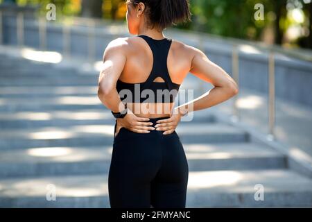 Donna nera che ha dolore alla schiena più basso, è stata ferita durante l'esercizio fisico Foto Stock