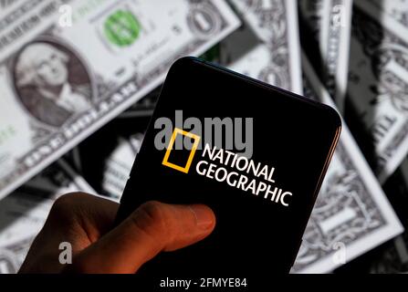 Cina. 23 Apr 2021. In questa illustrazione fotografica il giornale americano di scienza, cultura e natura e il logo digitale via cavo e della rete televisiva National Geographic (NG) visto su uno smartphone con la valuta USD (dollaro degli Stati Uniti) sullo sfondo. Credit: SOPA Images Limited/Alamy Live News Foto Stock