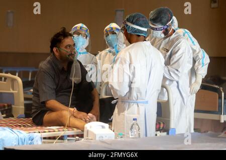 Nuova Delhi, India. 12 maggio 2021. Medici e personale sanitario che indossano dispositivi di protezione individuale (DPI), assistono i pazienti all'interno del centro di cura.presso Shehnai Banquet Hall, un centro di cura temporaneo per il paziente Covid-19 è stato istituito presso il Lok Nayak Jai Prakash Narayan (LNJP) Hospital, la più grande struttura di Covid 19-Only. (Foto di Naveen Sharma/SOPA Images/Sipa USA) Credit: Sipa USA/Alamy Live News Foto Stock