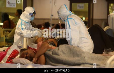 Nuova Delhi, India. 12 maggio 2021. Medici e personale sanitario che indossano dispositivi di protezione individuale (DPI), assistono i pazienti all'interno del centro di cura.presso Shehnai Banquet Hall, un centro di cura temporaneo per il paziente Covid-19 è stato istituito presso il Lok Nayak Jai Prakash Narayan (LNJP) Hospital, la più grande struttura di Covid 19-Only. (Foto di Naveen Sharma/SOPA Images/Sipa USA) Credit: Sipa USA/Alamy Live News Foto Stock