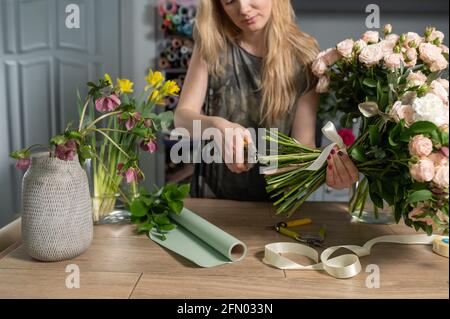 Concetto di negozio floreale . Donna fiorista crea bouquet di fiori. Bel bouquet di fiori misti. Bel mazzo fresco. Consegna fiori Foto Stock