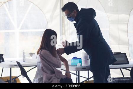 Toronto, Canada. 12 maggio 2021. Una donna riceve il vaccino COVID-19 in una clinica di vaccinazione a Toronto, Ontario, Canada, il 12 maggio 2021. A partire da mercoledì pomeriggio, il Canada ha riportato un totale complessivo di 1,305,174 casi COVID-19, di cui 24,765 morti, secondo CTV. Credit: Zou Zheng/Xinhua/Alamy Live News Foto Stock