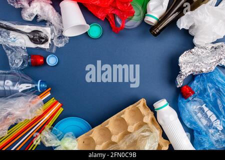 Campioni di rifiuti che possono essere riciclati isolati su sfondo blu. Spazio di copia Foto Stock