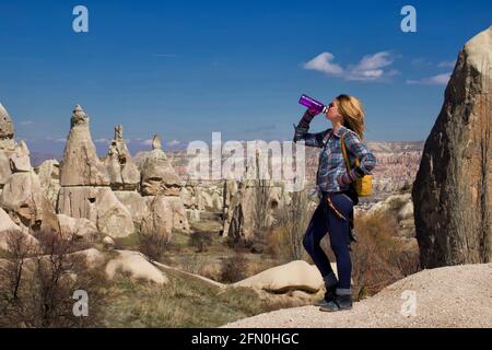 Donna escursionista che prende una bevanda in Cappadocia, Turchia Foto Stock