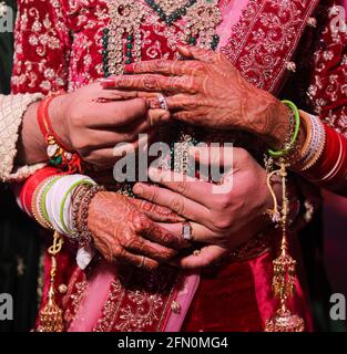 mano di coppia di nozze indiana con anelli di fidanzamento. Foto Stock