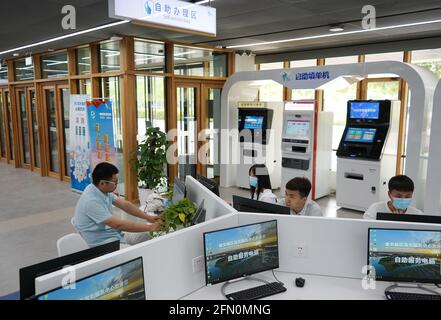 (210513) -- XIONGAN, 13 maggio 2021 (Xinhua) -- i cittadini utilizzano i computer nell'area self-service del Centro servizi amministrativi della nuova area di Xiongan, nella Nuova area di Xiongan, nella provincia di Hebei, nella Cina settentrionale, 12 maggio 2021. Fondato il 30 maggio del 2018 e composto da diverse aree funzionali, il Centro servizi amministrativi di Xiongan New Area funge da centro di servizi "one-stop" per fornire revisione amministrativa e approvazione e trattare con l'azienda per comodità di imprese e privati. Come uno dei metodi per contribuire a promuovere la creazione di una città digitale, il centro servizi presenta un Foto Stock