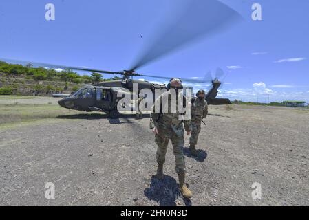 La Union, El Salvador. 12 maggio 2021. I membri dell'esercito DEGLI STATI UNITI si allontanano da un elicottero Black Hawk UH-60L. La forza di lavoro congiunta del comando meridionale degli Stati Uniti-Bravo ha eseguito operazioni congiunte a El Salvador, Guatemala e Honduras, dove ha fornito assistenza medica agli ospedali e alle comunità locali. Nella città di la Union sono stati dispiegati circa 60 militari statunitensi per aiutare un ospedale e piccole isole che non hanno cure mediche. (Foto di Camilo Freedman/SOPA Images/Sipa USA) Credit: Sipa USA/Alamy Live News Foto Stock