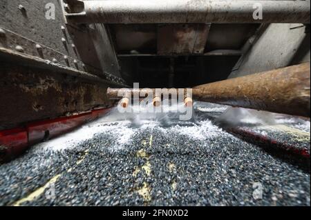 Schermo vibrante, lavaggio con liquido. Un sacco di piccole pietre sulla superficie del setaccio Foto Stock