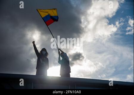 Bogotà, Colombia. 12 maggio 2021. Un dimostratore fa ondate una bandiera colombiana come Bogotà, Colombia entra nella sua terza settimana di proteste antigovernali contro il presidente Ivan Duque Marquez e le morti che si sommano fino a 40 in casi di brutalità della polizia durante lo Sciopero Nazionale, il 12 maggio 2021. Credit: Long Visual Press/Alamy Live News Foto Stock