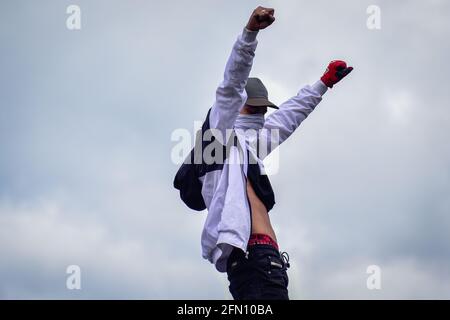 Passo, Colombia. 12 maggio 2021. Il demostratore Hooded alza le braccia in tromba mentre attraversa la mobilitazione che aveva raggiunto il parco principale della città di Pato, Narino, Colombia il 12 maggio 2021 Credit: Long Visual Press/Alamy Live News Foto Stock