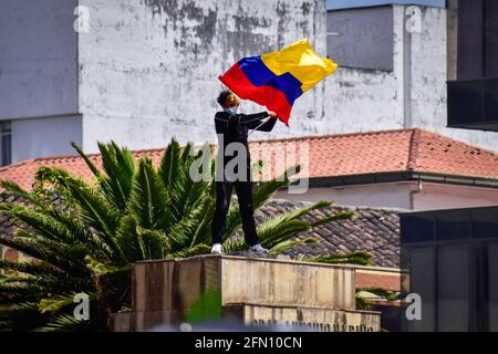 Passo, Colombia. 12 maggio 2021. Demostrator ondeggia la bandiera della Colombia nel luogo dove si trovava la statua di Antonio Narino, che fu rimossa la notte prima nel centro della città di Pato, Narino il 12 maggio 2021 Credit: Long Visual Press/Alamy Live News Foto Stock