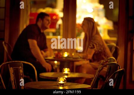 Storie d'amore. Un uomo e una donna in un caffè bere caffè a lume di candela. Foto Stock