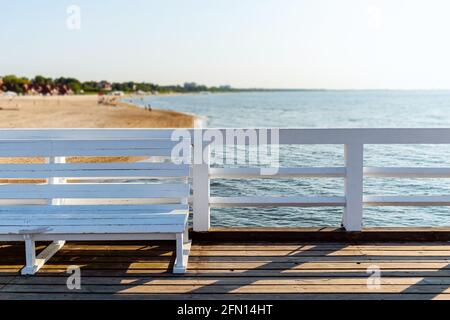 panca di legno bianco sul vecchio molo di legno e vista mare Foto Stock